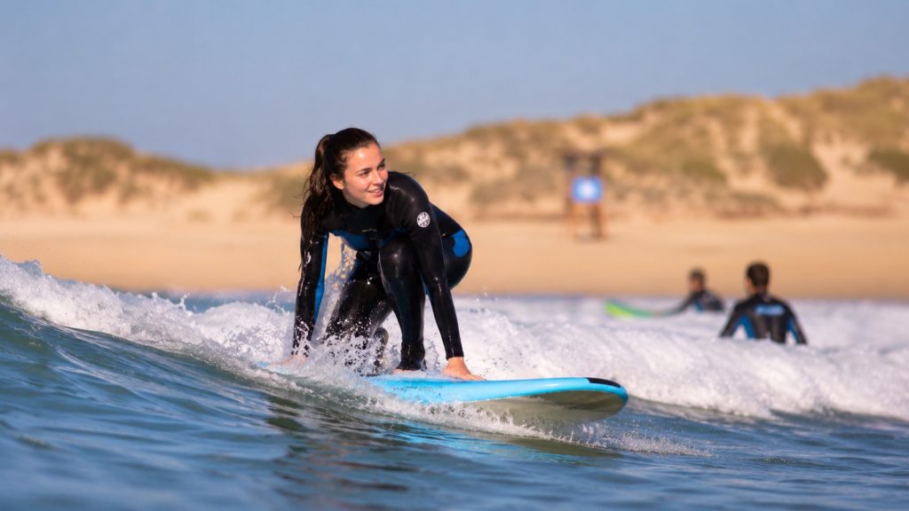 Débutante en surf sur une planche en mousse dans les mousses, plage atlantique