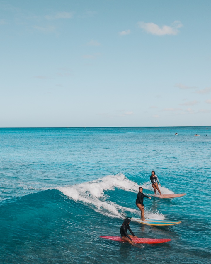 Deux surfeurs sur une vague dans une mer turquoise